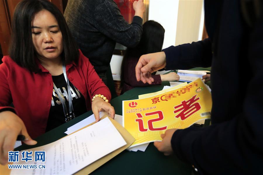 參加全國政協(xié)十二屆五次會(huì)議采訪報(bào)道的記者領(lǐng)取證件