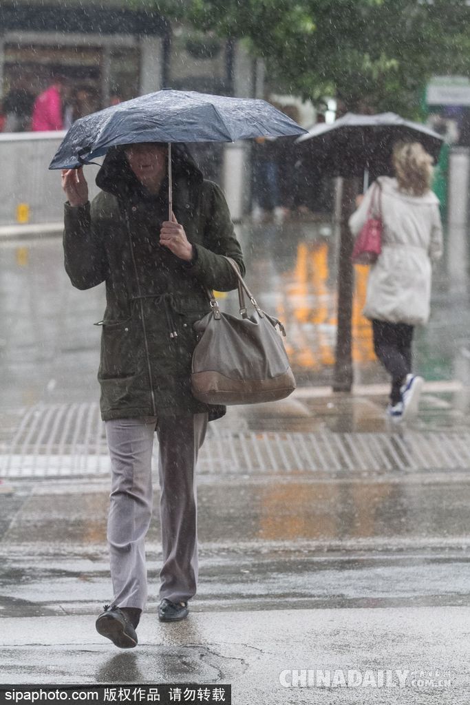 英國倫敦雨天狂風(fēng)大作 民眾出行雨傘被吹翻