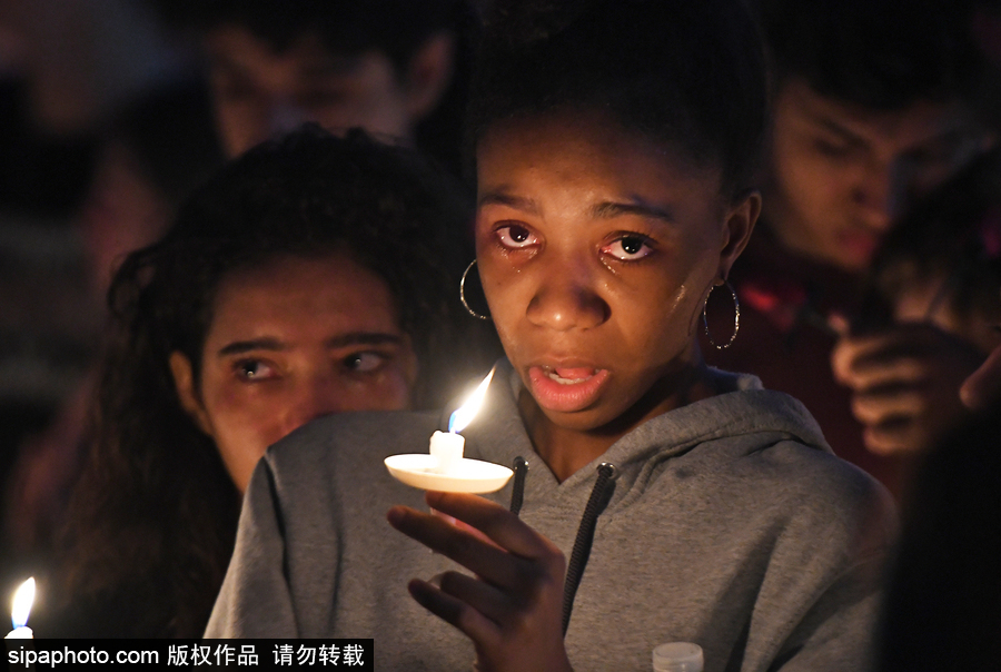 美國：民眾學(xué)生集會點(diǎn)蠟悼念高中槍擊案遇難者