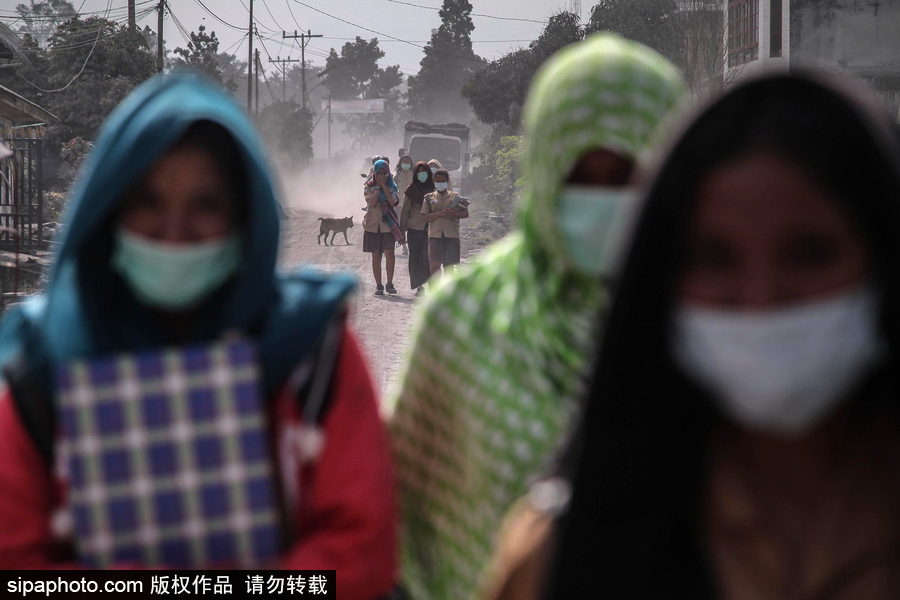 錫納朋火山噴發后 火山灰漫山遍野村民戴口罩清掃