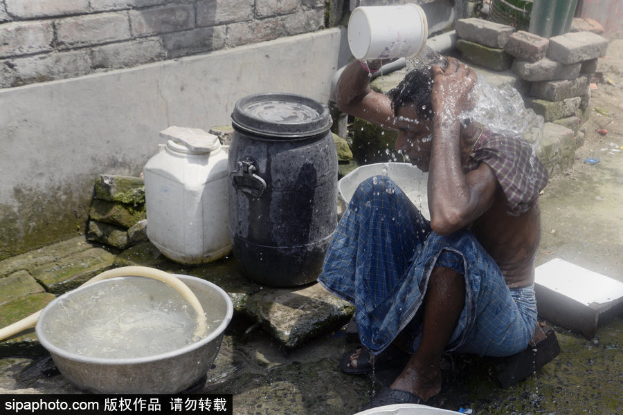 印度加爾各答高溫來(lái)襲 民眾室外沖涼降溫